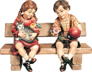 Bub und Mädchen sitzend auf Bank