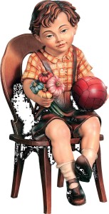 Bambino seduto con pallone e fiori su sedia